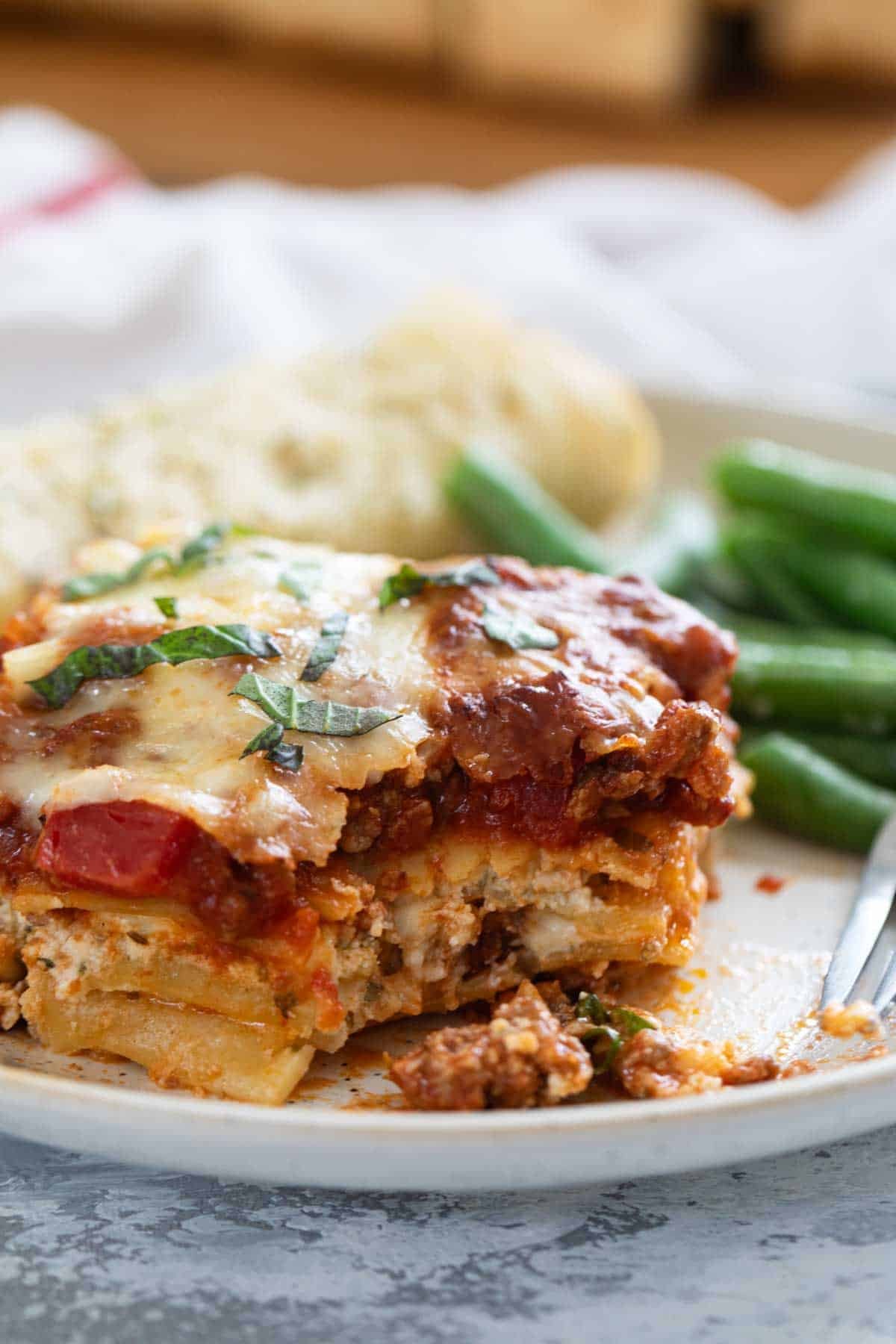 Slice of lasagna with a bite taken from it.