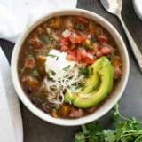 Bowl of Black Bean and Ham Soup topped with sour cream, pico de Gallo, cheese, and avocado.