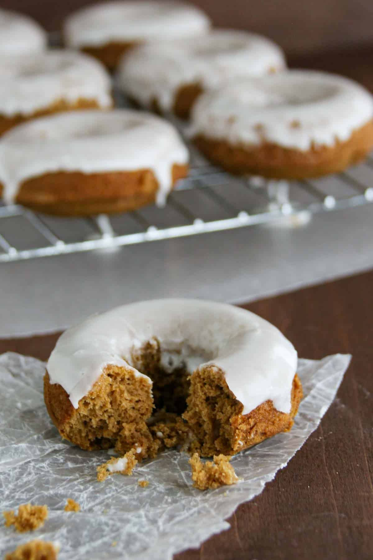 Glazed Gingerbread Baked Donuts with a bite taken from one donut.