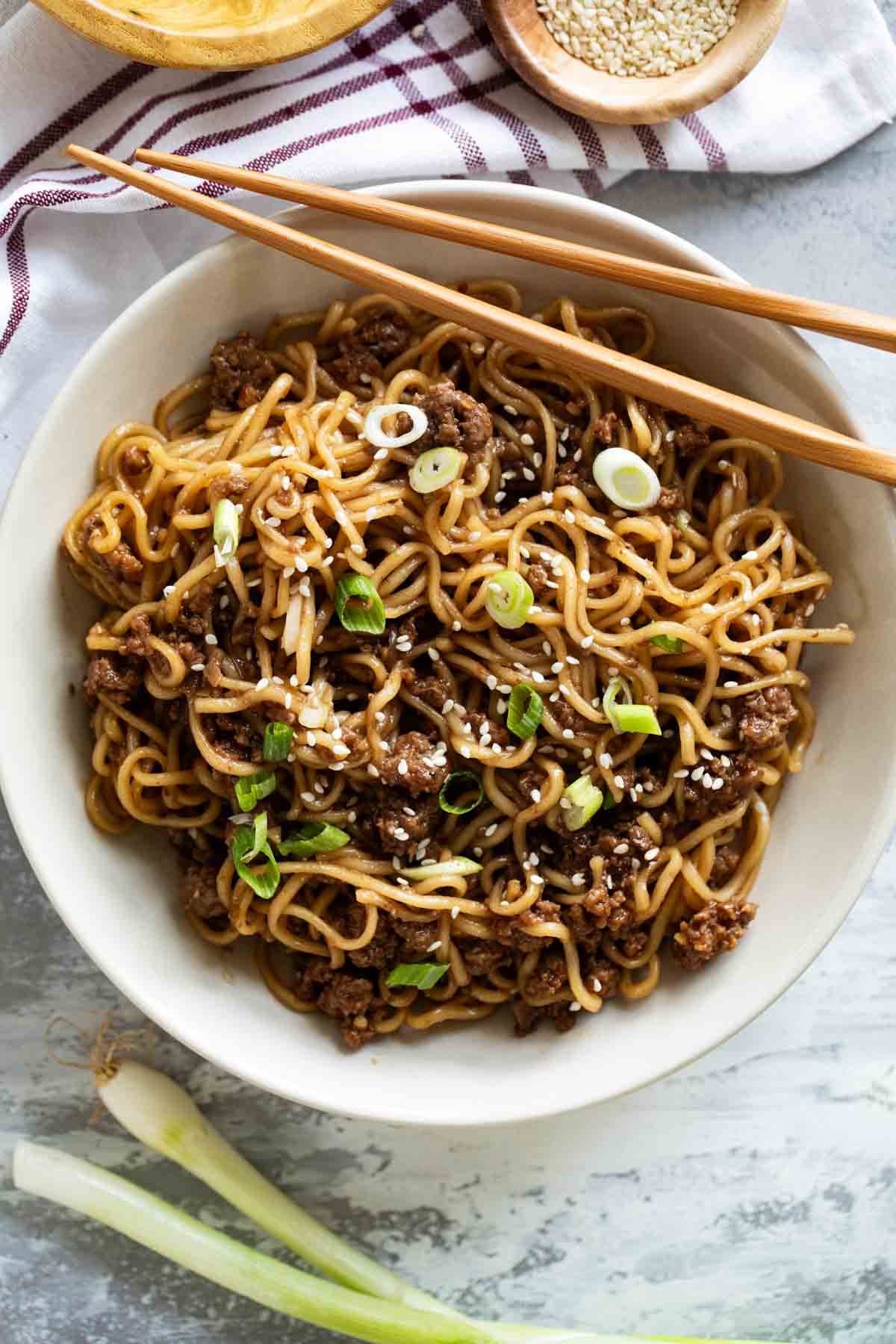 Bowl filled with Mongolian Ground Beef Noodles with chopsticks on the side.