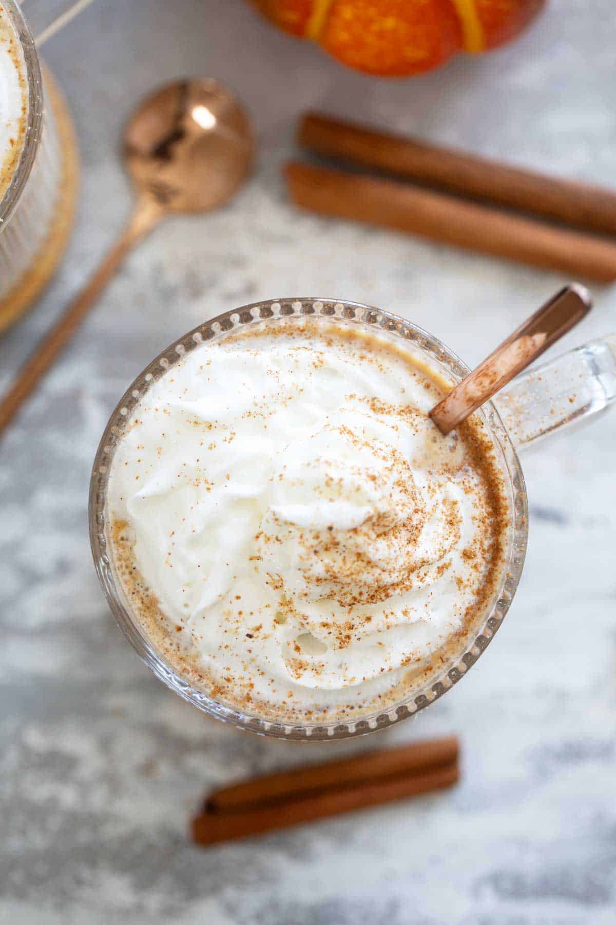 Whipped cream topped with spices on a pumpkin steamer.