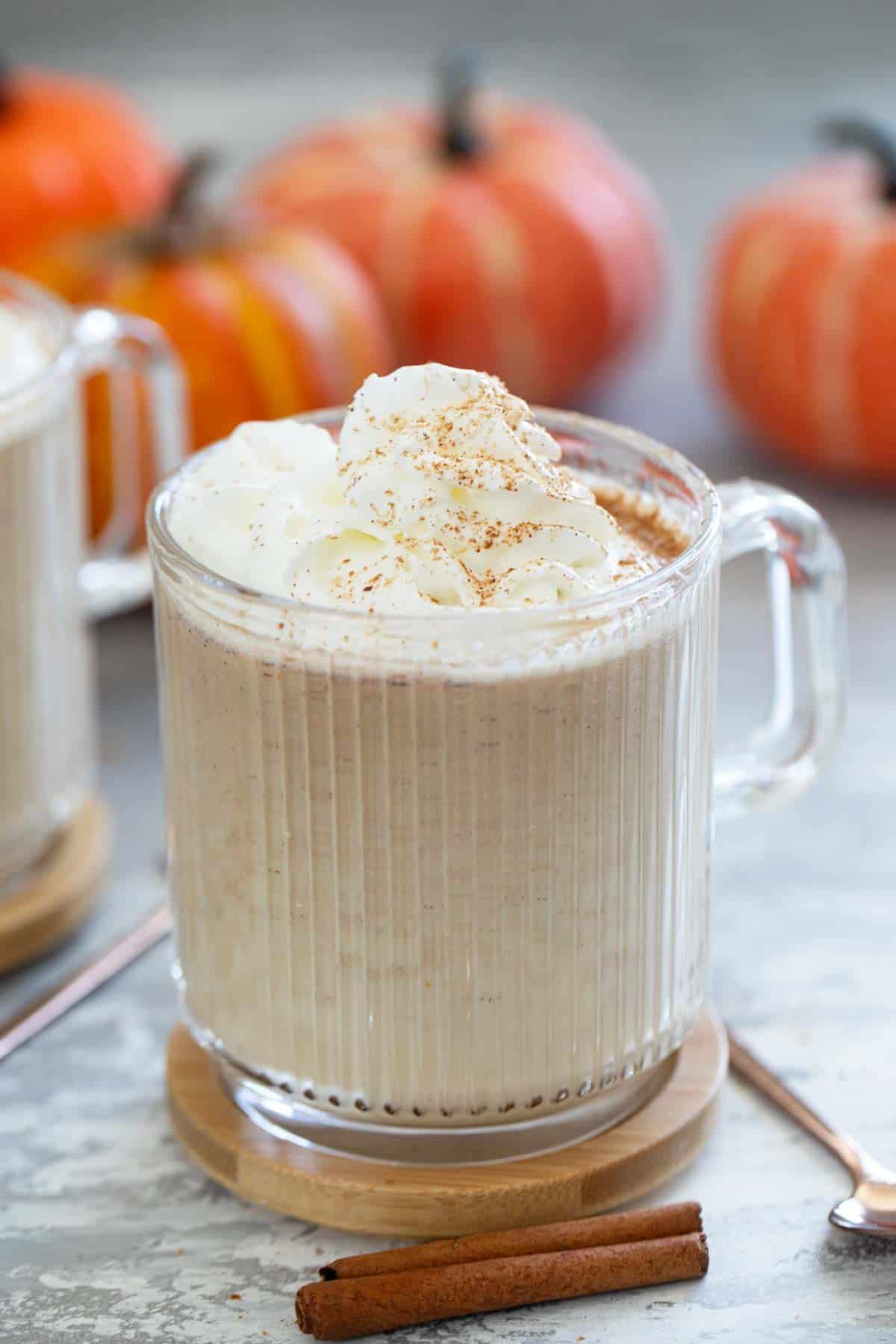 Glass mug with Pumpkin Steamer topped with whipped cream.