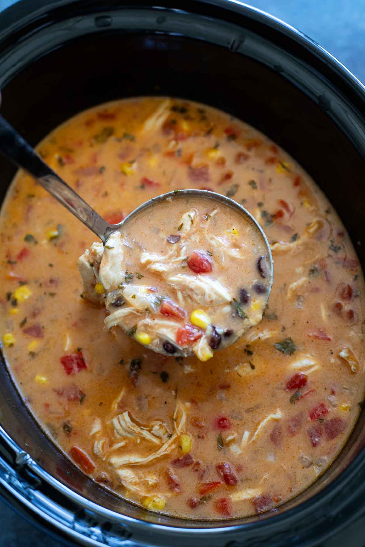 Slow cooker filled with chicken enchilada soup.