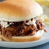 Słów cooker pulled pork served as a sandwich with coleslaw.