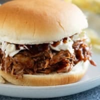 Słów cooker pulled pork served as a sandwich with coleslaw.