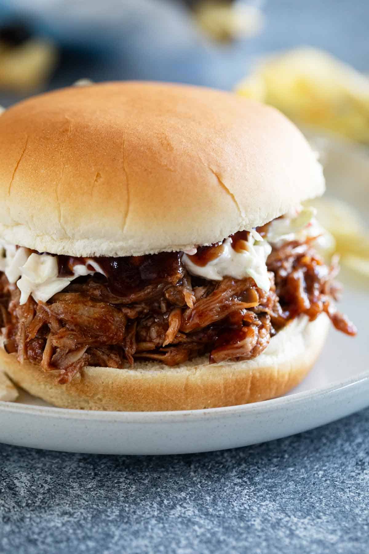 Słów cooker pulled pork served as a sandwich with coleslaw.
