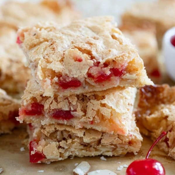 Three coconut cherry almond bars stacked on top of each other.