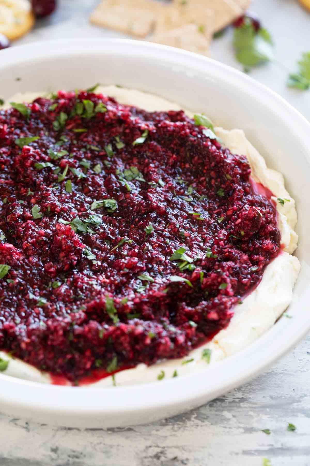 Cranberry Cream Cheese Dip in a dish, topped with chopped cilantro.
