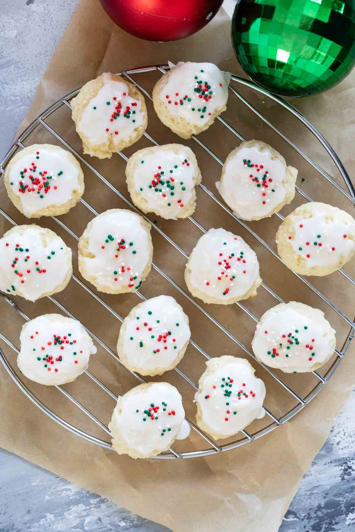 Italian Christmas cookies with red and green sprinkles on a cooling rack.