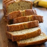 Loaf of buttermilk banana bread on a cutting board, cut into slices.