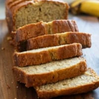 Loaf of buttermilk banana bread on a cutting board, cut into slices.