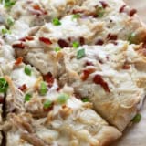 Chicken Alfredo Pizza with bacon and green onions.