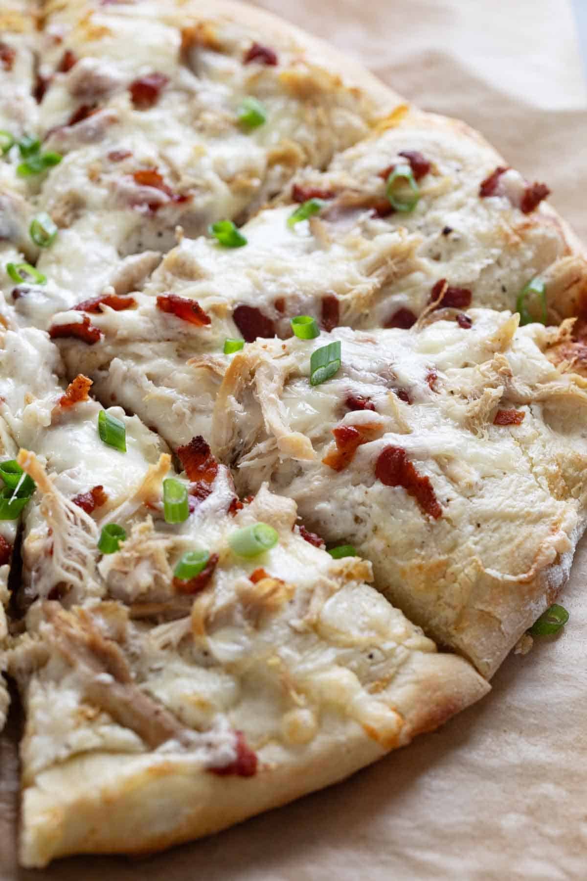 Chicken Alfredo Pizza with bacon and green onions.