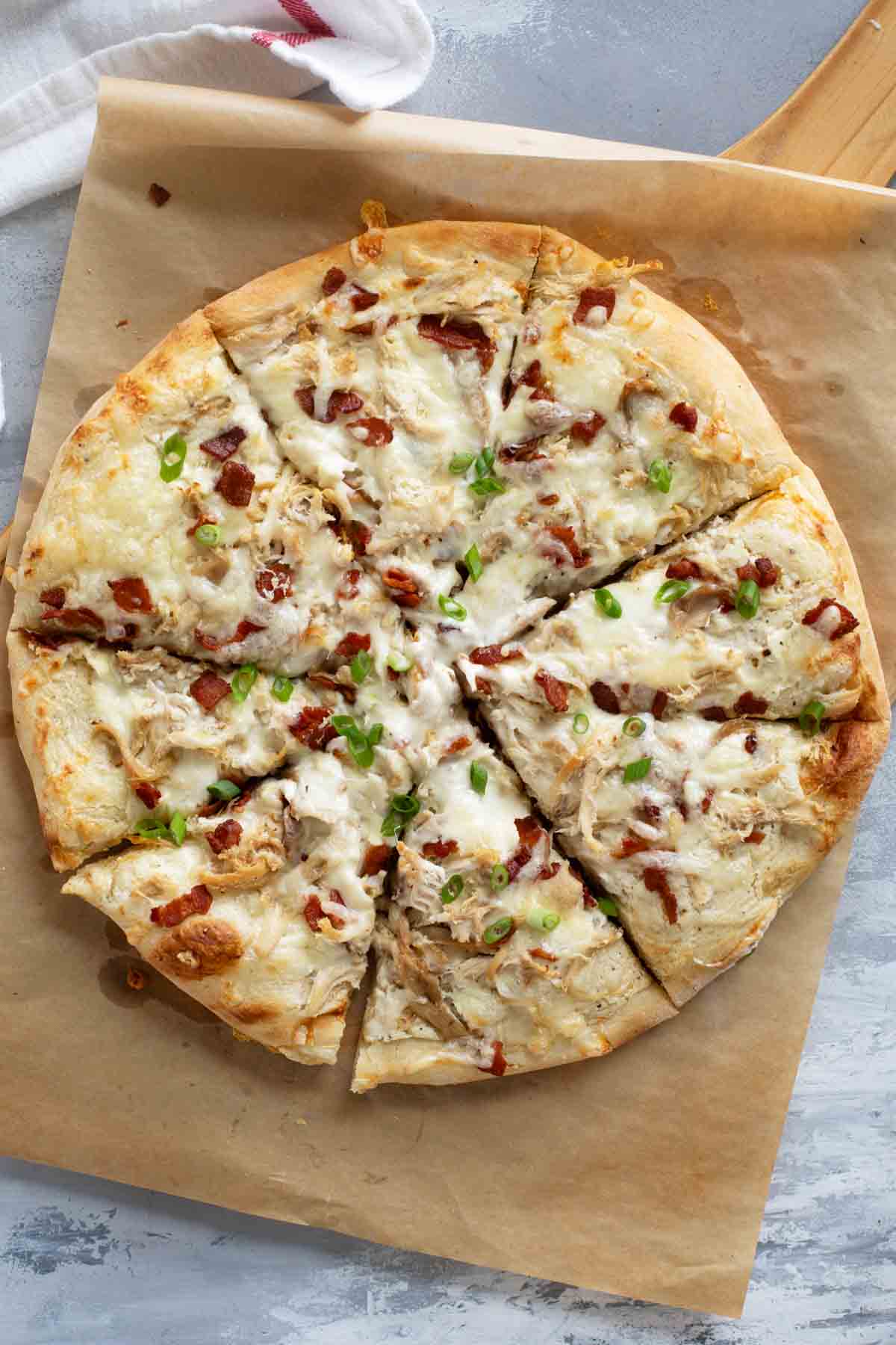 Full Chicken Alfredo Pizza on parchment paper.