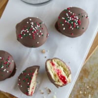 Chocolate Cherry Sandwich Cookies with one cookie broken in half.