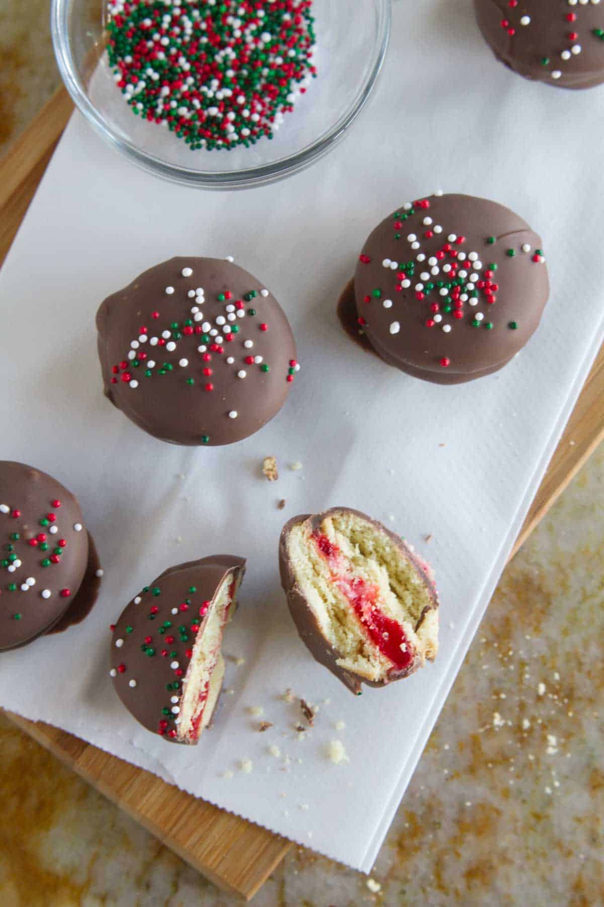 Chocolate Cherry Sandwich Cookies with one cookie broken in half.