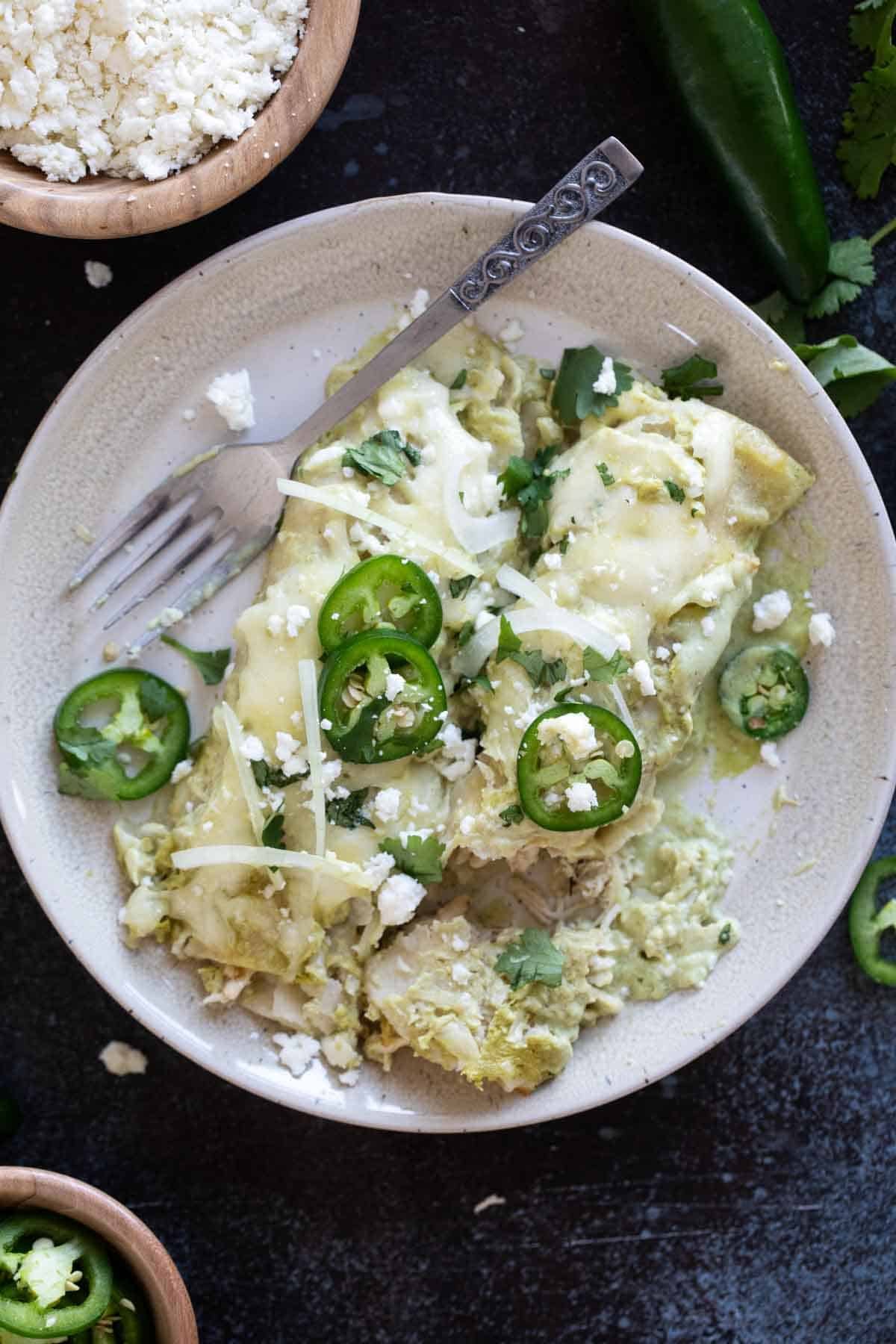 Enchiladas Suizas on a plate with a fork.