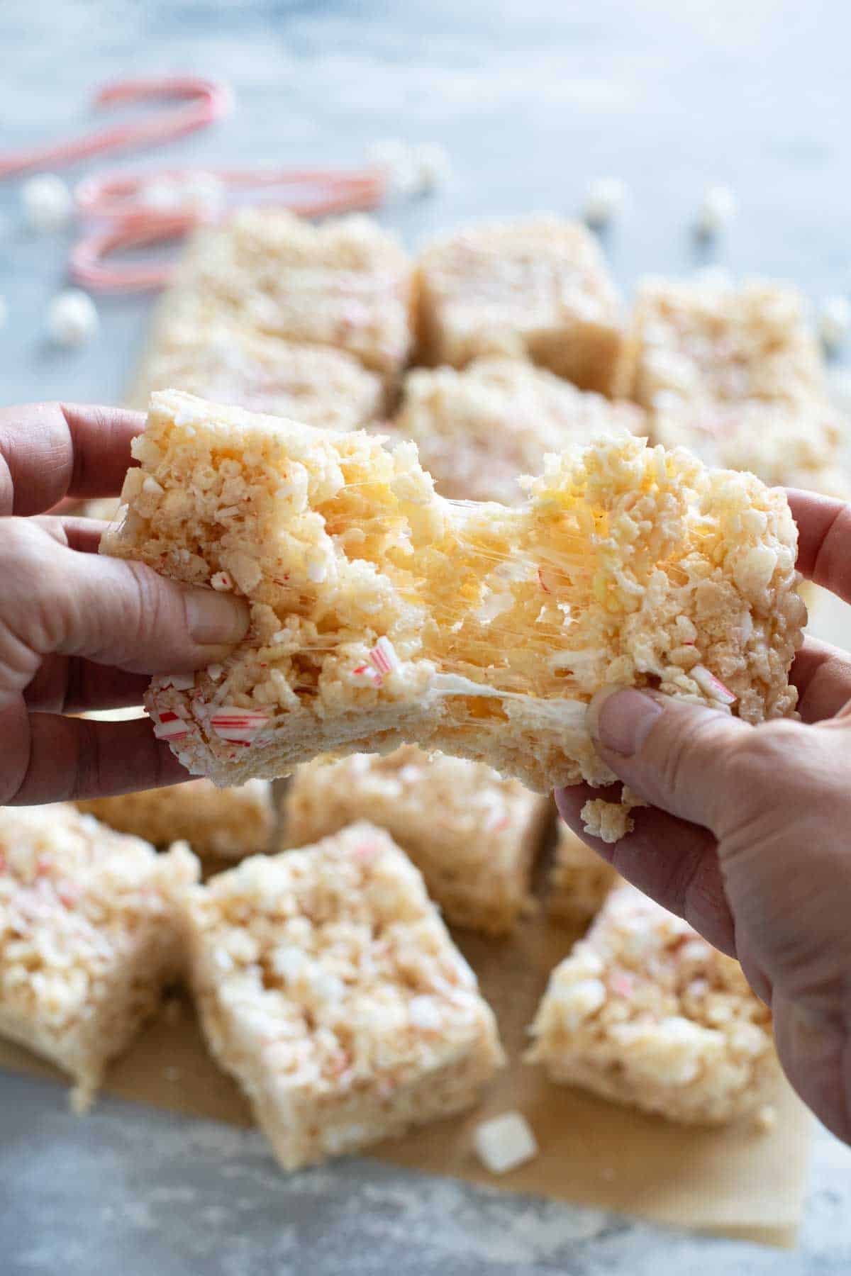 Tearing a peppermint rice krispie treat in half.