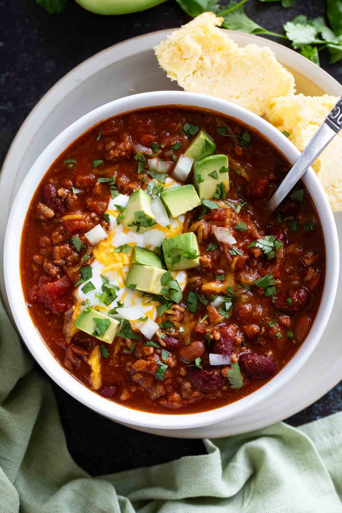 Bowl of Flatlander Chili topped with cheese, avocado, and sour cream.