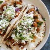 Honey Garlic Chicken Tacos with flour tortillas, topped with slaw.