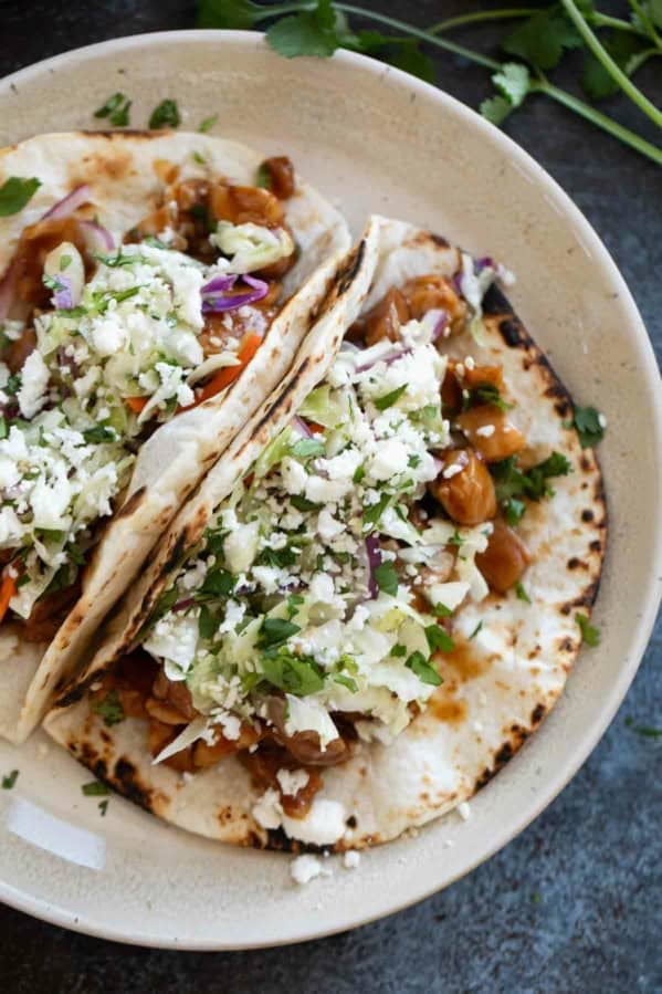 Honey Garlic Chicken Tacos with flour tortillas, topped with slaw.