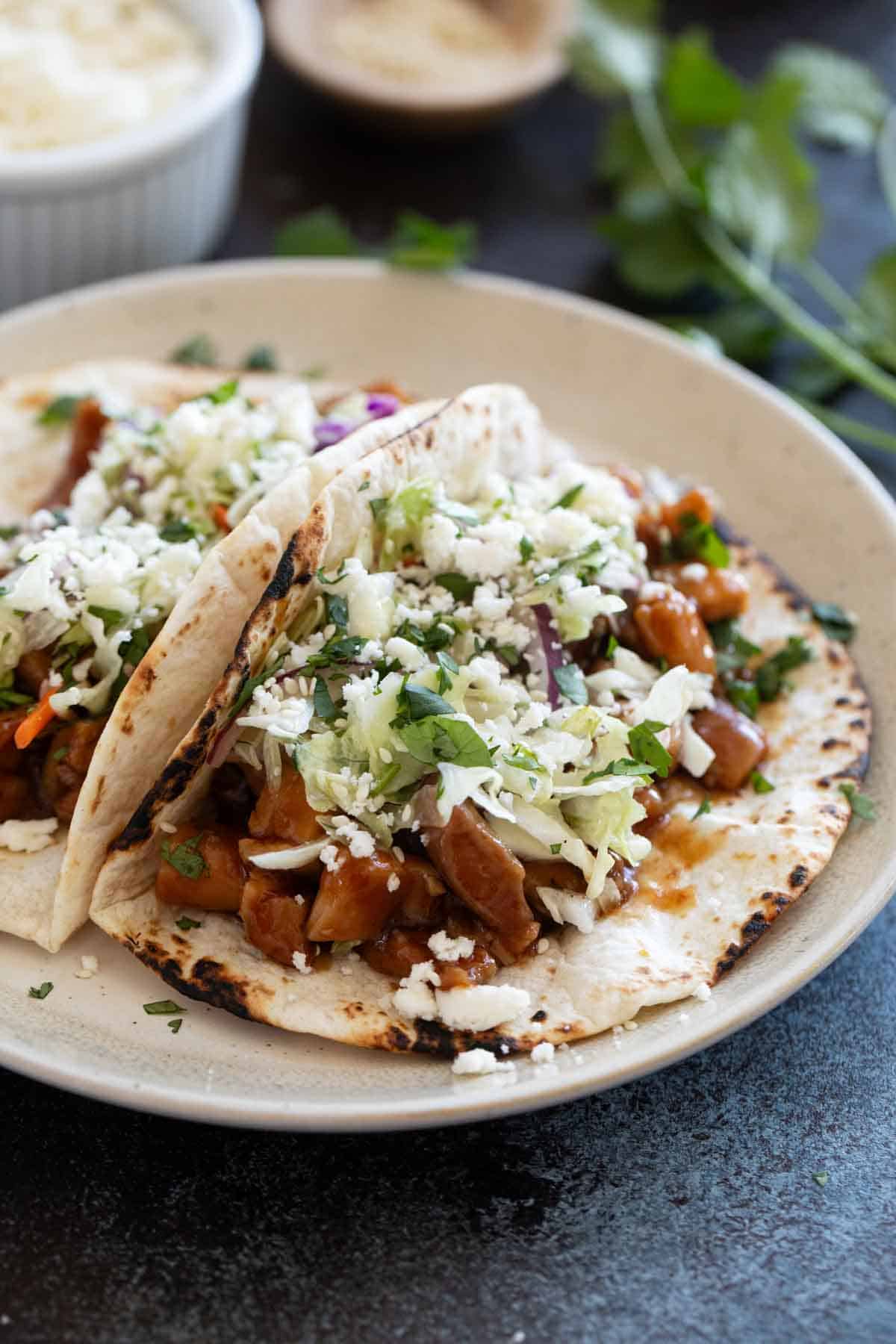 Honey Garlic Chicken Tacos topped with slaw.