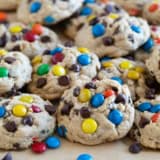 Monster Cookies stacked on a baking sheet.