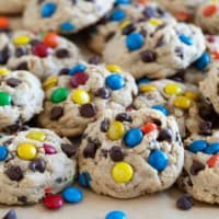 Monster Cookies stacked on a baking sheet.