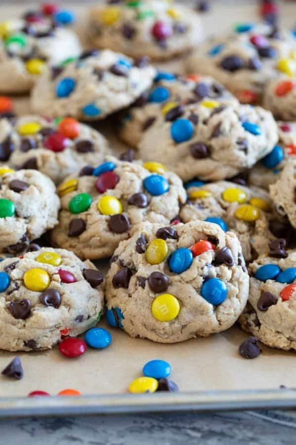 Monster Cookies stacked on a baking sheet.