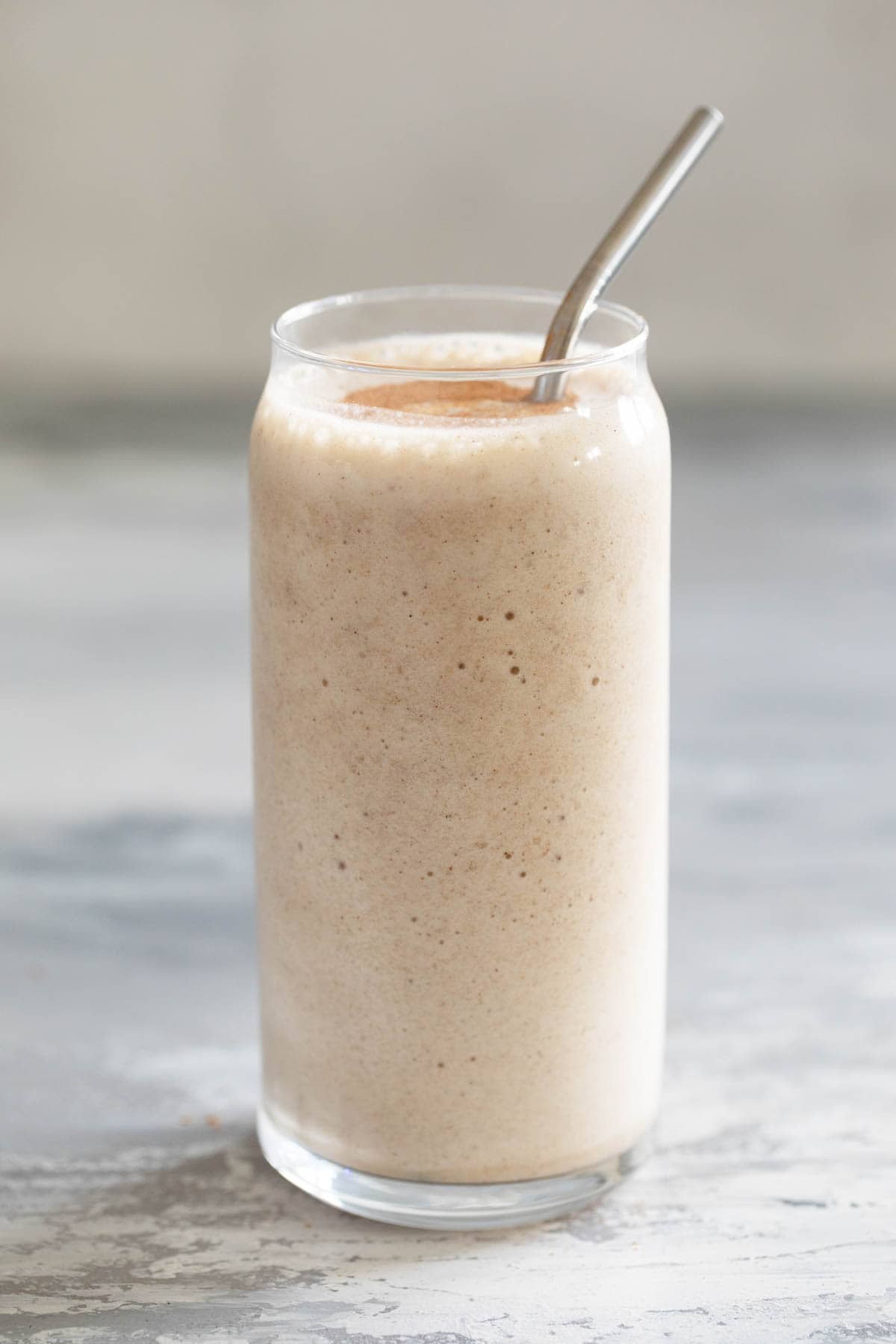 Vanilla Chai Smoothie in a glass with a metal straw.