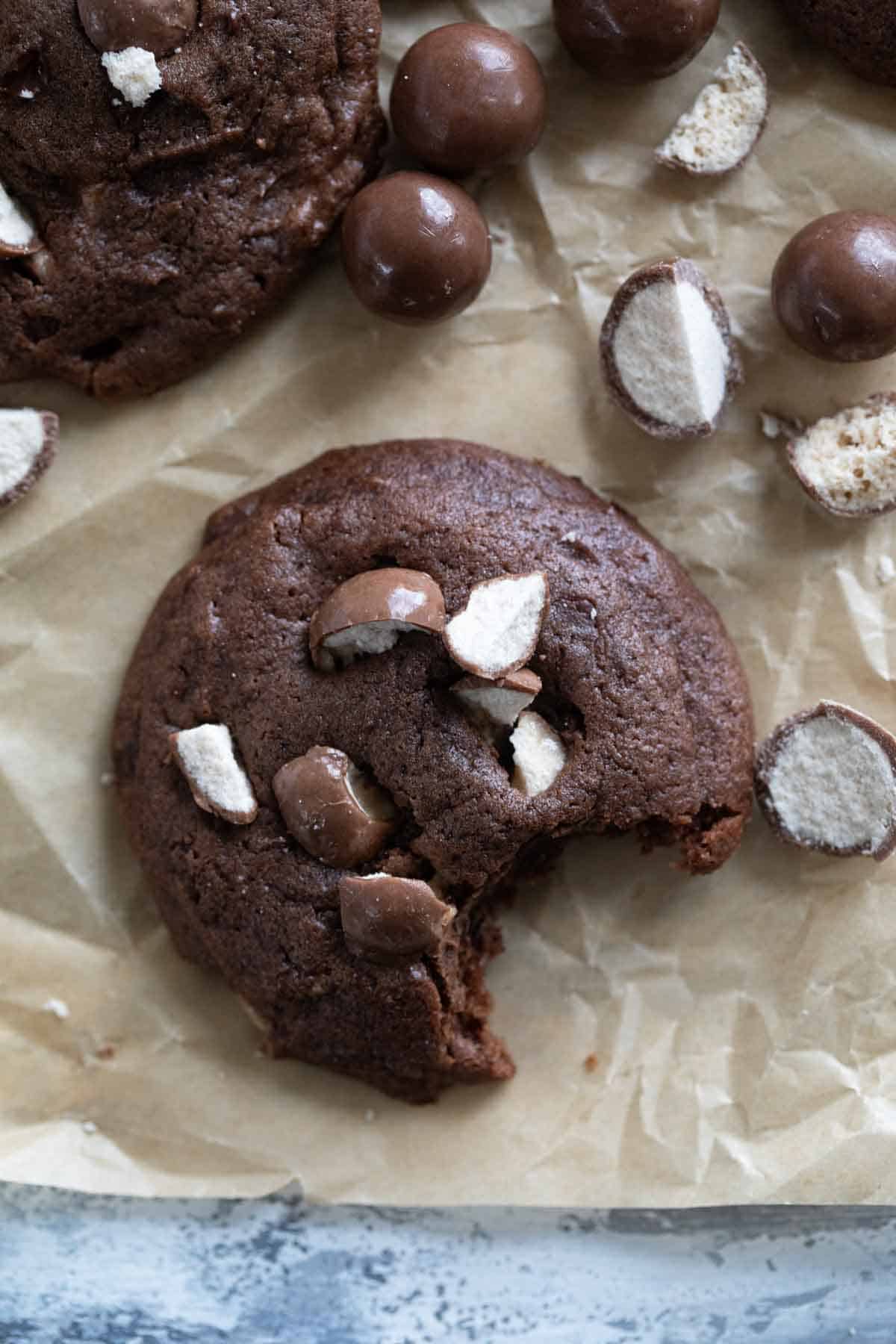 Chocolate Malted Milk Cookies with a bite taken from one cookie.