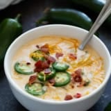 Bowl of Jalapeno Popper Soup topped with cheese, bacon, and jalapeno slices.