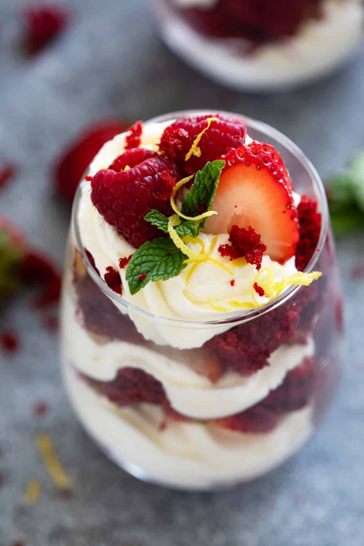 Red Velvet Trifle topped with strawberries, raspberries, and lemon peel.