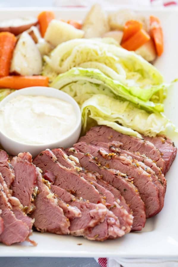 Sliced corned beef, cabbage, potatoes, and carrots on a serving dish.