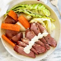 Sliced corned beef, cabbage, potatoes, and carrots with creamy horseradish mustard.