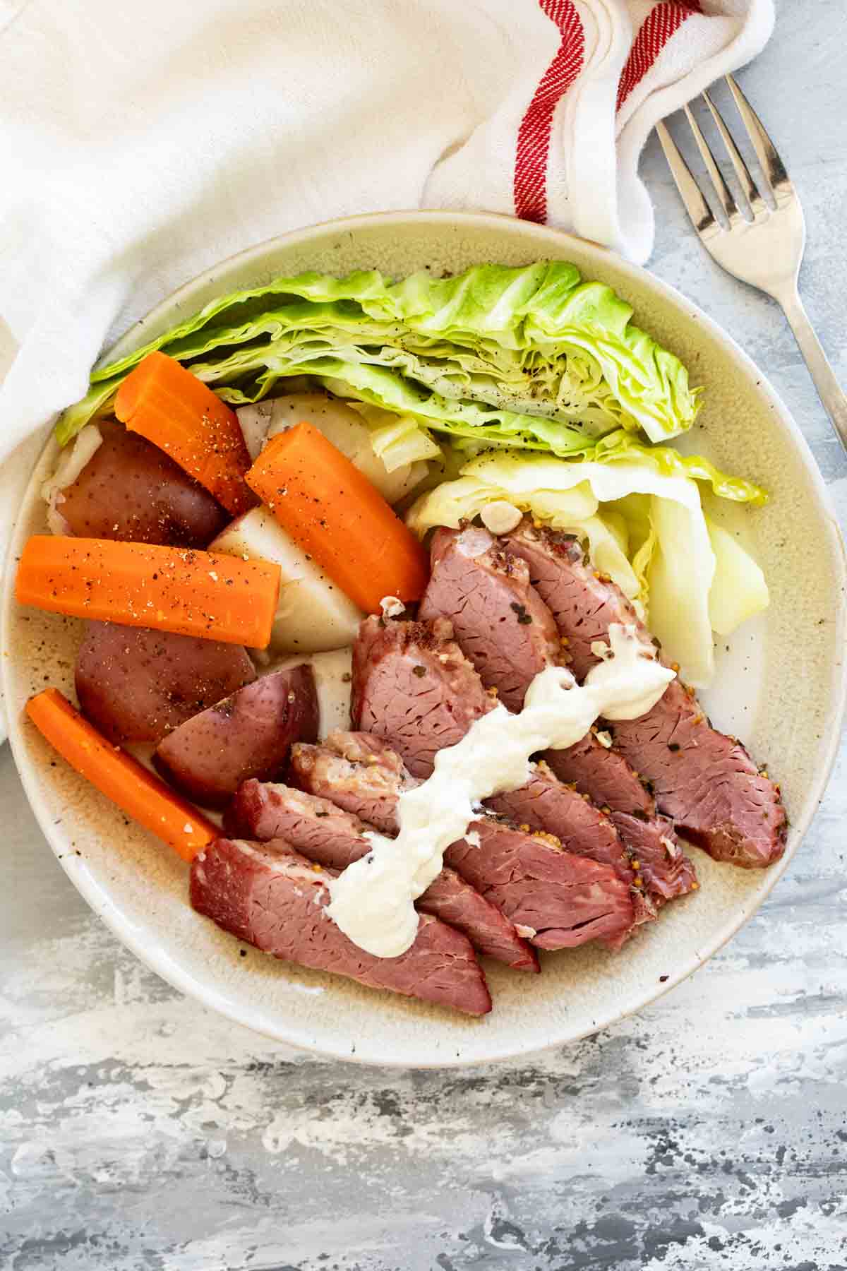 Sliced corned beef, cabbage, potatoes, and carrots with creamy horseradish mustard.