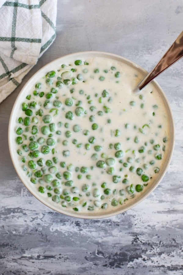Serving bowl filled with Creamed Peas.