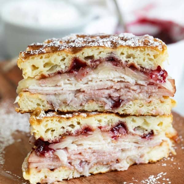 Monte Cristo Waffle Sandwich cut in half and stacked and dusted with powdered sugar.