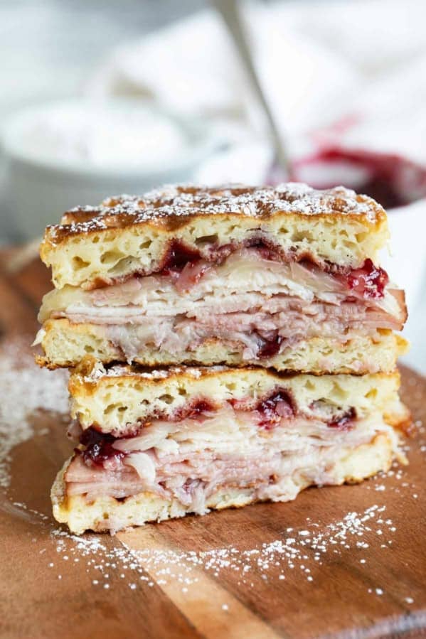 Monte Cristo Waffle Sandwich cut in half and stacked and dusted with powdered sugar.