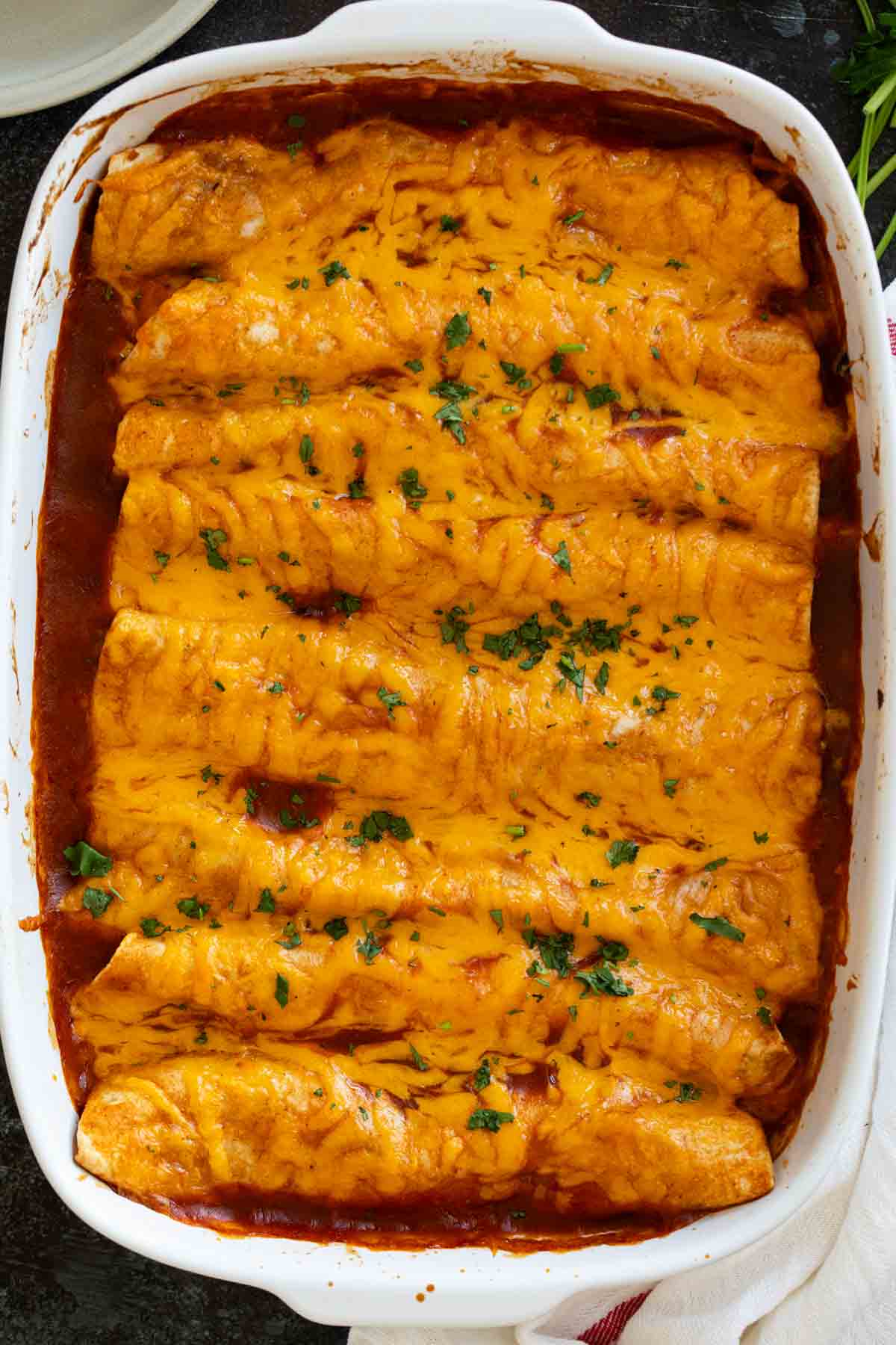 Casserole dish full of sweet potato and black bean enchiladas.