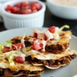 Bacon Cheeseburger Quesadillas cut into triangles and served with lettuce, tomatoes, and special sauce.