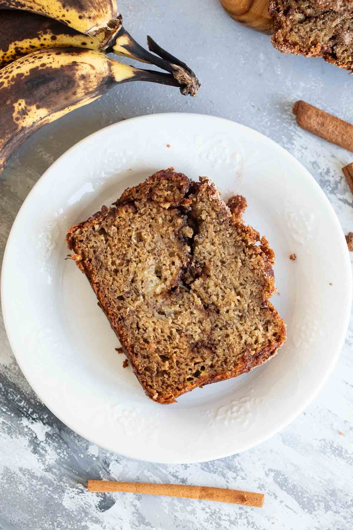 Slice of cinnamon banana bread on a white plate.