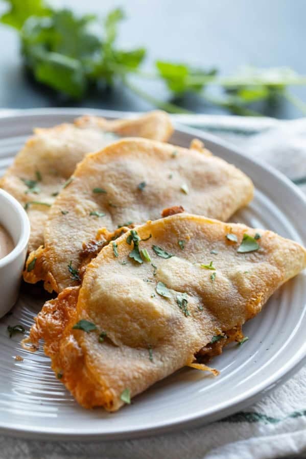 Crispy Chicken Tacos on a plate with chipotle dipping sauce.