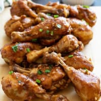 Honey Balsamic Chicken Drumsticks stacked on a cutting board.