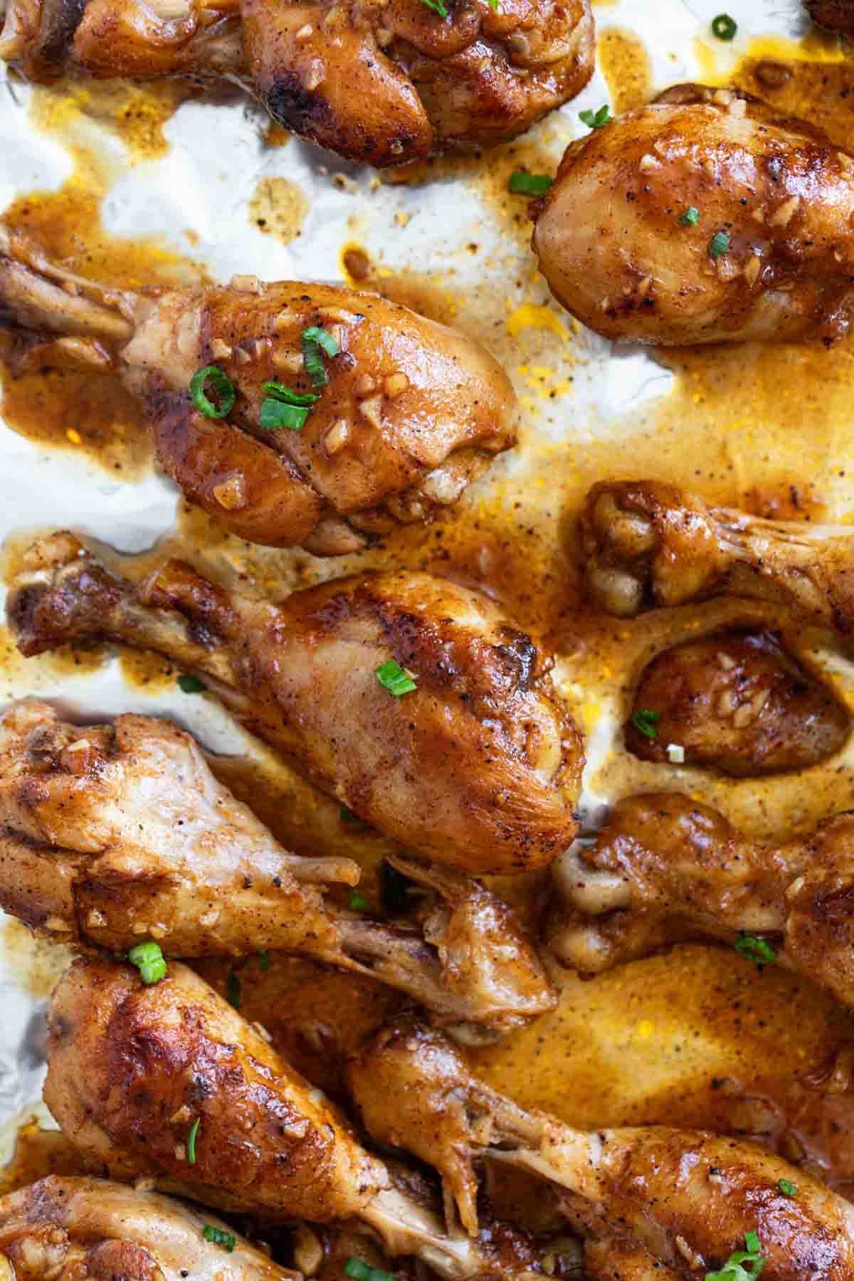 Honey Balsamic Chicken Drumsticks on a baking sheet lined with foil.