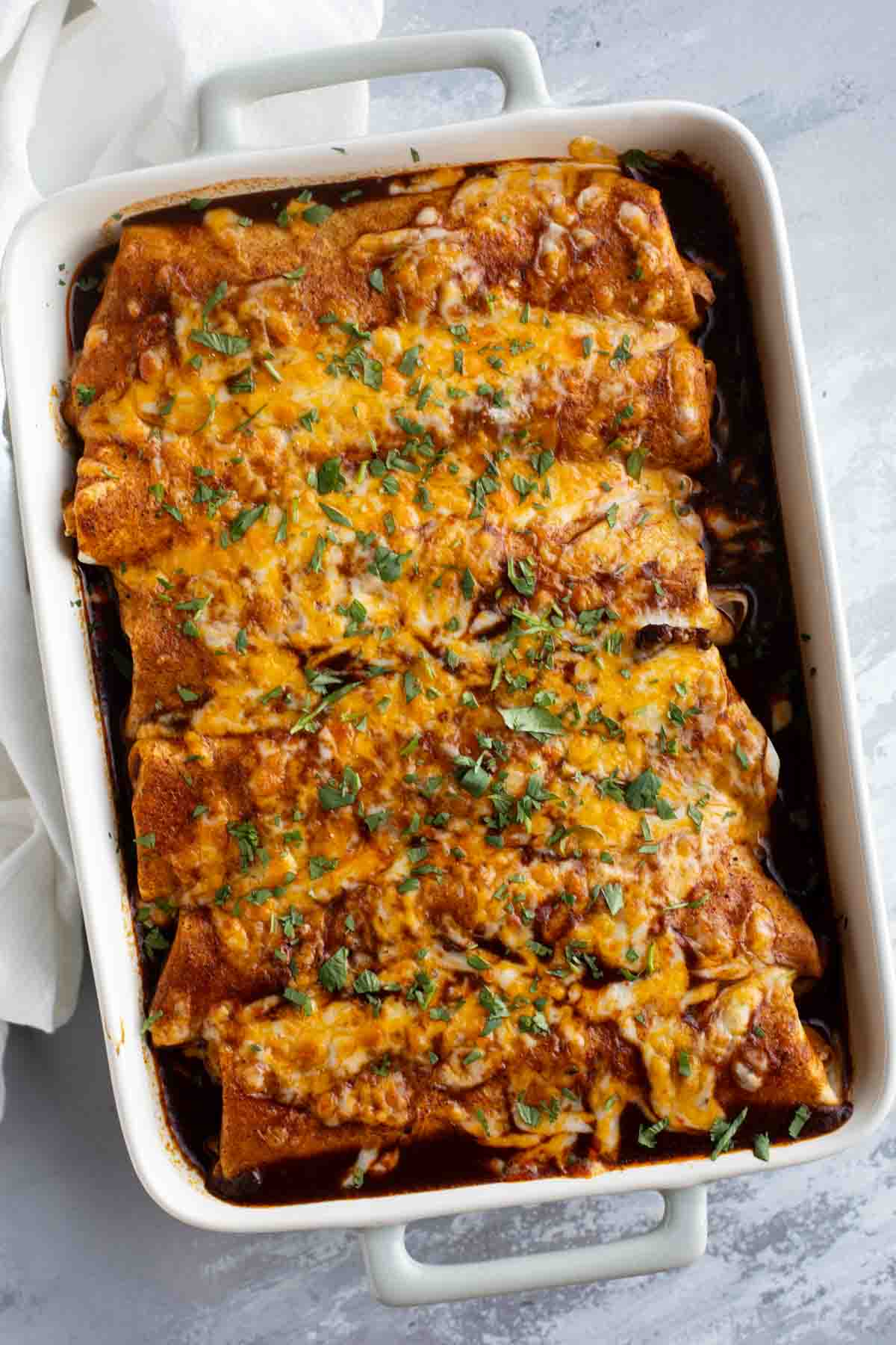 Casserole dish filled with Slow Cooker Chile Colorado Burritos.