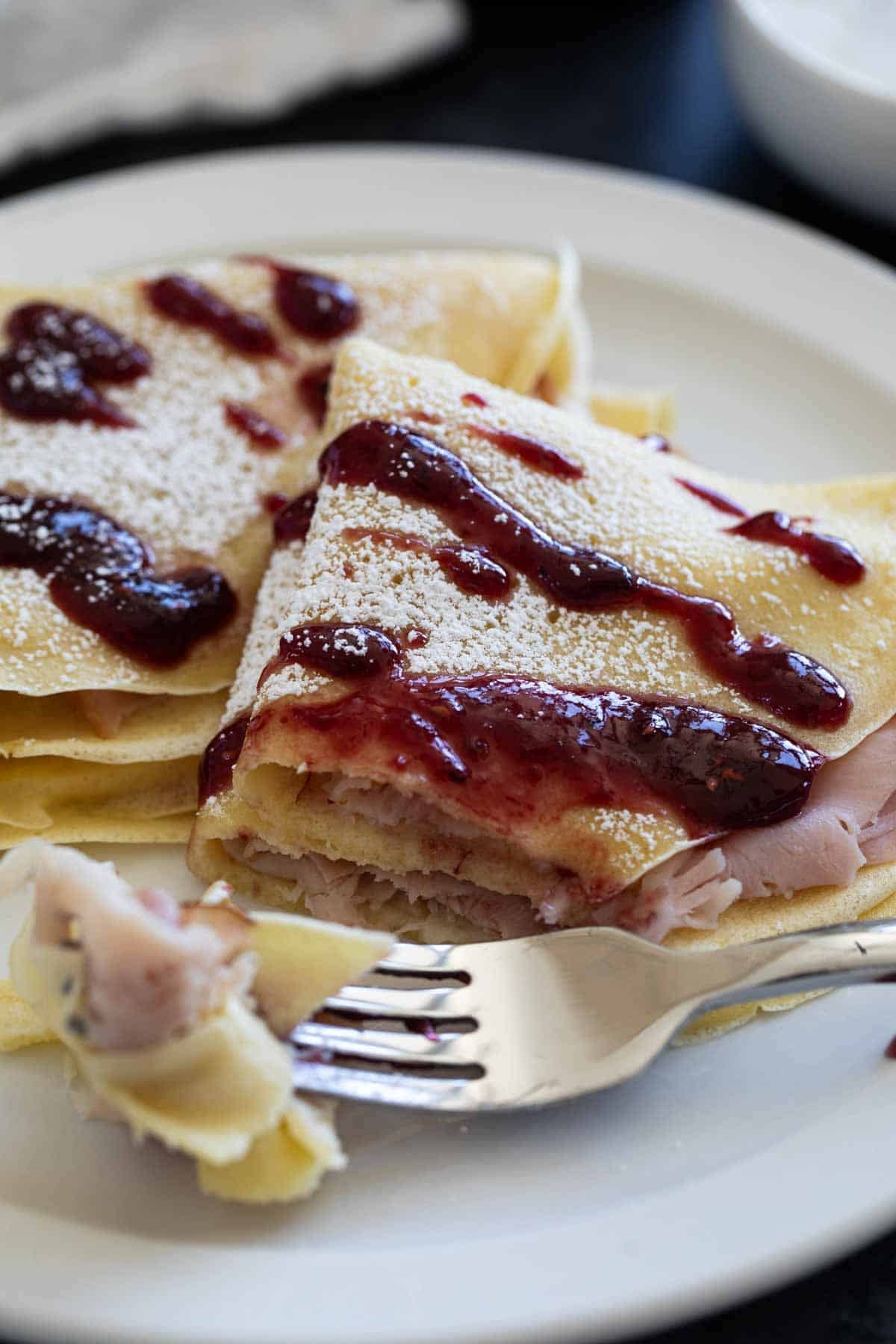 Monte Cristo Crepes with a fork full of crepe.