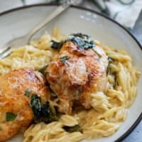 Chicken Orzo Bake topped with parmesan cheese on a plate.