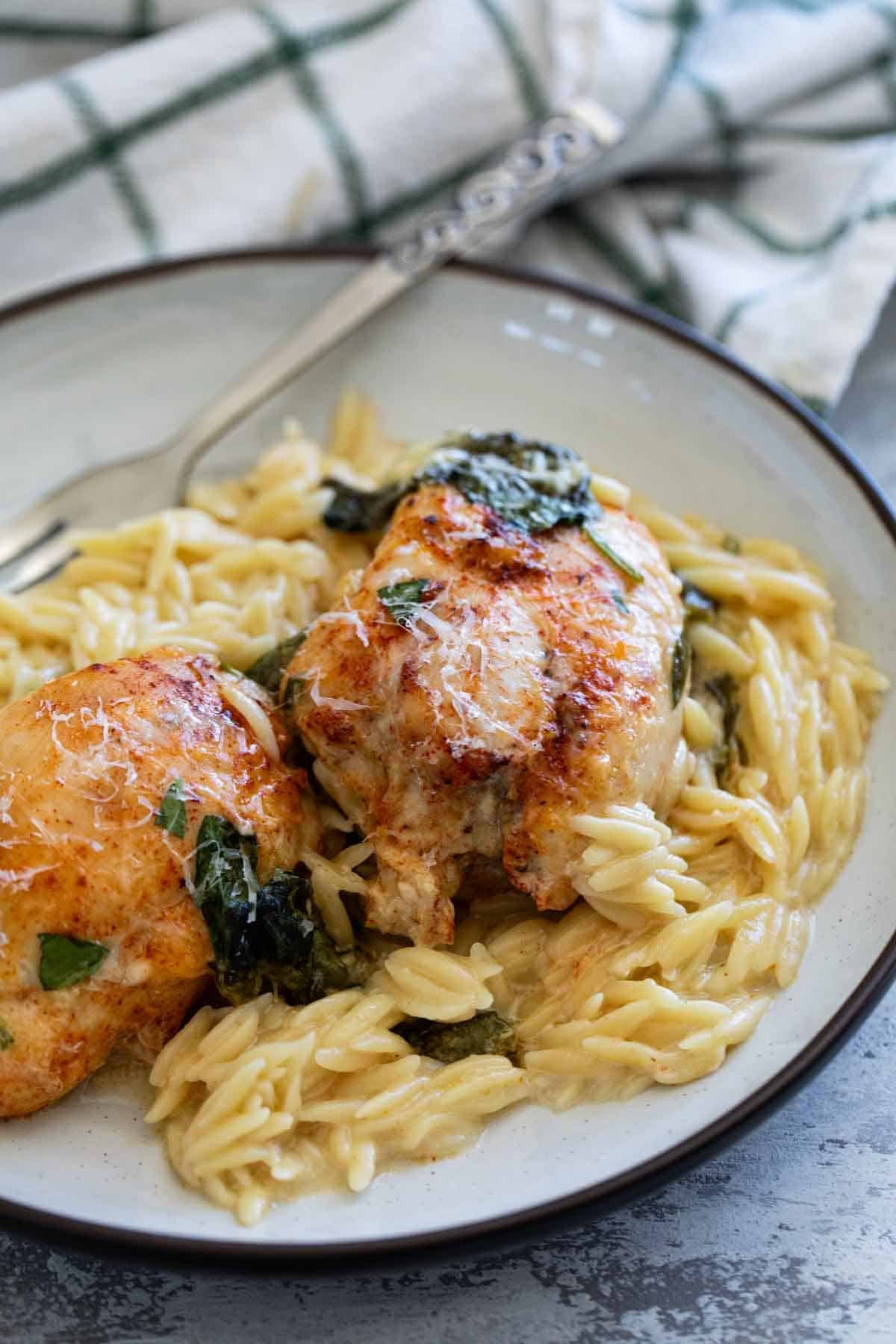 Chicken Orzo Bake topped with parmesan cheese on a plate.