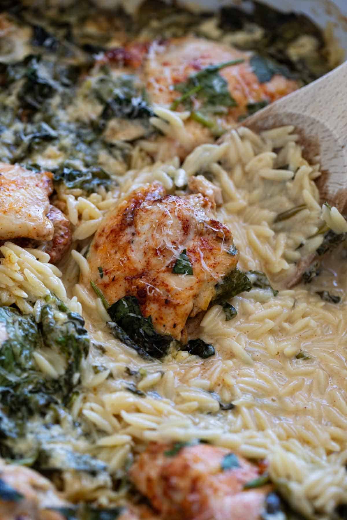 Chicken Orzo Bake with a wooden serving spoon.